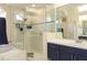Bathroom featuring a glass-enclosed shower, soaking tub, vanity with ample storage, and neutral tile at 13942 Talmage Loop, Hudson, FL 34667