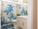 Charming bathroom with nautical-themed décor, a white vanity, and a shower with turtle curtain at 13942 Talmage Loop, Hudson, FL 34667