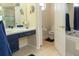 Bright bathroom featuring a vanity with navy blue cabinets, a soaking tub, and separate toilet room at 13942 Talmage Loop, Hudson, FL 34667