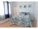 Light and airy bedroom featuring a large window, a comfortable queen bed, and charming wall art at 13942 Talmage Loop, Hudson, FL 34667
