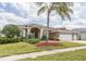 Charming single-story home with a three-car garage, a palm tree, and mature landscaping at 13942 Talmage Loop, Hudson, FL 34667