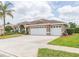 Lovely one-story home with a three-car garage, fresh exterior paint, a green lawn and manicured shrubs at 13942 Talmage Loop, Hudson, FL 34667