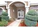 Arched entryway with decorative double doors framed by columns and manicured shrubbery at 13942 Talmage Loop, Hudson, FL 34667