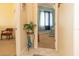 A bright hallway showcases tile floors, a decorative plant, and a peek into a cozy bedroom with soft lighting at 13942 Talmage Loop, Hudson, FL 34667
