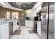 The kitchen boasts stainless steel appliances, white cabinets, and tile flooring for a modern feel at 13942 Talmage Loop, Hudson, FL 34667