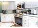 Modern kitchen showcases stainless steel appliances, white cabinets, and ample counter space at 13942 Talmage Loop, Hudson, FL 34667