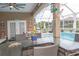 View of the pool and lanai with patio furniture and outdoor kitchen at 13942 Talmage Loop, Hudson, FL 34667
