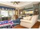 Open concept living room featuring lanai access, comfortable seating, and view to the kitchen at 13942 Talmage Loop, Hudson, FL 34667