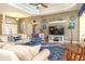 Inviting living room with a tray ceiling, comfortable seating, a large TV, and elegant decor at 13942 Talmage Loop, Hudson, FL 34667