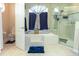Serene main bathroom with a soaking tub, glass-enclosed shower, and neutral tile at 13942 Talmage Loop, Hudson, FL 34667
