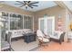 Relaxing covered patio with comfortable seating, tiki decor, and a ceiling fan at 13942 Talmage Loop, Hudson, FL 34667