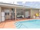 An outdoor pool featuring an outdoor bar and screened-in lanai and lounge area at 13942 Talmage Loop, Hudson, FL 34667