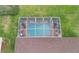 Aerial view of a screened in swimming pool with an attached patio area and manicured landscaping at 13942 Talmage Loop, Hudson, FL 34667