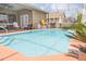 A backyard featuring an in-ground pool with blue tile and orange-colored decking at 13942 Talmage Loop, Hudson, FL 34667