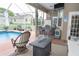 View of screened-in lanai with outdoor seating, kitchen, and a swimming pool at 13942 Talmage Loop, Hudson, FL 34667