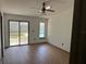 Bright bedroom with wood-look flooring, ceiling fan, sliding glass doors to backyard and a pool view at 1412 Wexford N Dr, Palm Harbor, FL 34683