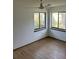Bright bedroom with hardwood floors, two windows and ceiling fan providing natural light at 1412 Wexford N Dr, Palm Harbor, FL 34683