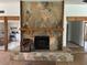 Inviting living space featuring a stone fireplace, wooden mantel, and views into the stainless steel kitchen at 1412 Wexford N Dr, Palm Harbor, FL 34683