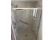 Modern bathroom featuring a glass-enclosed shower with chrome fixtures and grab bars, ensuring safety and accessibility at 1412 Wexford N Dr, Palm Harbor, FL 34683
