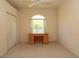 Functional bedroom with a built-in desk area and a closet for storage at 15038 Tamarind Loop, Spring Hill, FL 34609