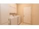 Bright laundry room with tile floors, washer, dryer, and ample storage cabinets at 15038 Tamarind Loop, Spring Hill, FL 34609