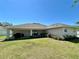 View of the backyard, showcasing the covered patio, lush lawn, and sliding glass doors at 15585 Rene Ct, Brooksville, FL 34604