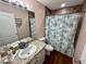 Bathroom features a vanity sink with granite countertop and tub shower with decorative curtain at 15585 Rene Ct, Brooksville, FL 34604
