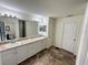 Bathroom featuring a double vanity with granite countertops, tile floor, and modern lighting fixtures at 15585 Rene Ct, Brooksville, FL 34604
