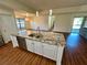 Kitchen island featuring a double sink, granite countertops, and seating for four, with an open concept to the dining area at 15585 Rene Ct, Brooksville, FL 34604
