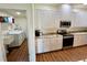 Open kitchen with laundry room access, granite countertops, stainless appliances, and ample white cabinets at 15585 Rene Ct, Brooksville, FL 34604