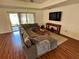 Spacious living room featuring a large sectional sofa, wood floors, and a sliding glass door to the outside at 15585 Rene Ct, Brooksville, FL 34604