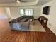 Comfortable living room with a sectional sofa, wood-look floors, and a large television for entertainment at 15585 Rene Ct, Brooksville, FL 34604