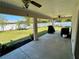 A covered patio with ceiling fans provides shade to the backyard with a privacy fence and simple landscaping at 15585 Rene Ct, Brooksville, FL 34604