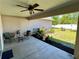 Covered patio area with seating, plants, and a view of the landscaped backyard at 15585 Rene Ct, Brooksville, FL 34604