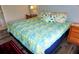 Inviting bedroom featuring a large bed with floral bedding, wood floors, and a wooden nightstand with a lamp at 1881 Mazo Mnr # I-6, Lutz, FL 33558