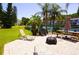 An inviting outdoor patio area with chairs, picnic table, and lake view in a tropical setting at 1881 Mazo Mnr # I-6, Lutz, FL 33558