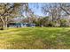 Large green backyard offers ample space and includes a shed with mature trees at 1916 & 1910 Beachway Ln, Odessa, FL 33556