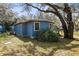 View of side of house with painted exterior, bushes, and mature tree at 1916 & 1910 Beachway Ln, Odessa, FL 33556