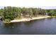 Beautiful lake view featuring a dock, sandy beach, and tree-lined shore, ideal for nature lovers at 1916 & 1910 Beachway Ln, Odessa, FL 33556