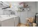 Laundry room featuring a washer, dryer, and shelving units at 1916 & 1910 Beachway Ln, Odessa, FL 33556