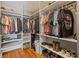 Walk-in closet with built in shelves, hanging rods and wood floor at 2400 Commack Ct, New Port Richey, FL 34655