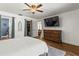 Bedroom with wood floors, ceiling fan, blue accents, ensuite bath, and walk-in closet at 2400 Commack Ct, New Port Richey, FL 34655