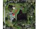Aerial view of a house with a pond behind it, offering a serene and private setting at 2400 Commack Ct, New Port Richey, FL 34655