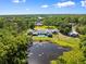 Panoramic aerial view of the property showcasing its pool, pond, and surrounding lush greenery at 2400 Commack Ct, New Port Richey, FL 34655