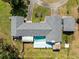 Aerial view of the property showcasing the pool, tiki hut, and sprawling landscaping at 2400 Commack Ct, New Port Richey, FL 34655