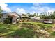 Expansive backyard with green grass, mature trees, and a charming porch swing at 2400 Commack Ct, New Port Richey, FL 34655