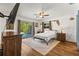 Bright bedroom featuring wood floors, a ceiling fan, a TV, and sliding glass doors to the pool area at 2400 Commack Ct, New Port Richey, FL 34655