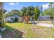 Large backyard with lush grass, wooden playground, and storage building at 2400 Commack Ct, New Port Richey, FL 34655