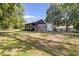 Exterior of the home with a trailer and covered storage, surrounded by mature trees at 2400 Commack Ct, New Port Richey, FL 34655