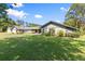 Charming single-story home with an attached garage and a large front yard with an American flag displayed at 2400 Commack Ct, New Port Richey, FL 34655